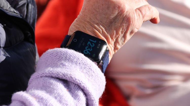 Senior med Sensorem trygghetslarm på armen. Larmet fungerar utomhus och utan hemtjänst