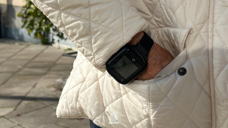 Sensoremin turvahälytin GPS-kellossa lisää eläkeläisten turvallisuutta ja toimii ulkona ja kaikkialla. Seniori älykello käsivarressa. Käsi taskussa