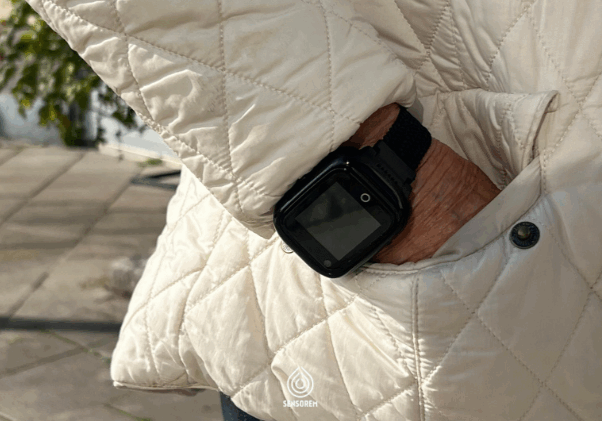 Sensorems trygghetslarm i GPSklocka ökar tryggheten för seniorer och fungerar utomhus och överallt. Senior med smartklocka på armen. Handen i fickan